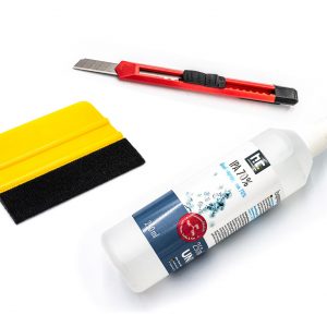 Kit de pose d'adhésif mural comprenant un flacon de nettoyage, un cutter rouge et une raclette d'application jaune