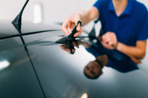Homme qui découpe un film teinté pour vitre